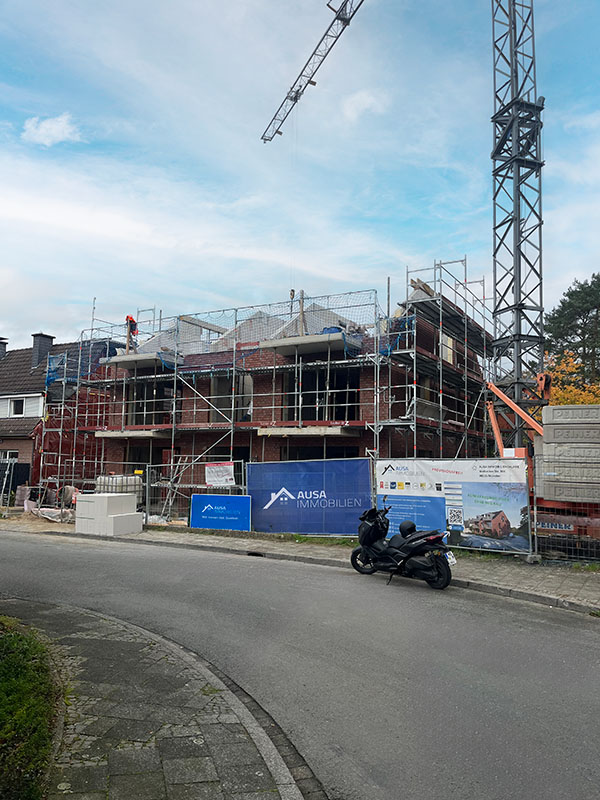 Baustelle der Bauwerk GmbH in Münster – Mehrfamilienhaus im Rohbau mit AUSA Immobilien Bautafel