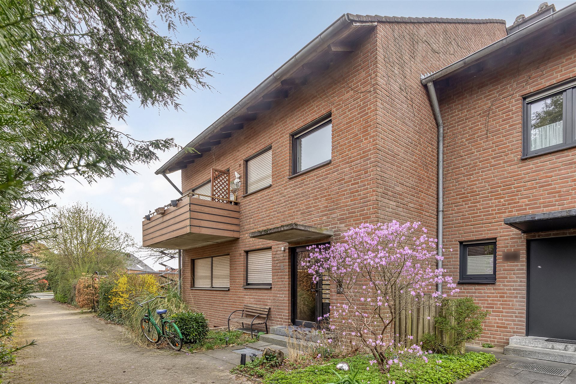 Mehrfamilienhaus Münster-Wolbeck – Seitenansicht mit Eingang und Garten