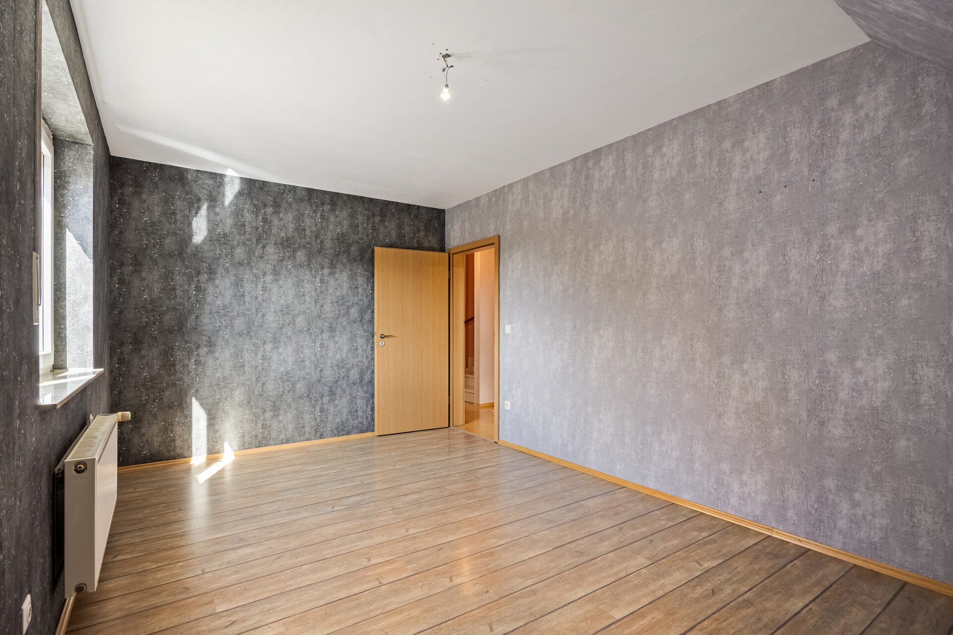 Doppelhaushälfte Gronau – Zimmer mit Holzboden und moderner Wandgestaltung