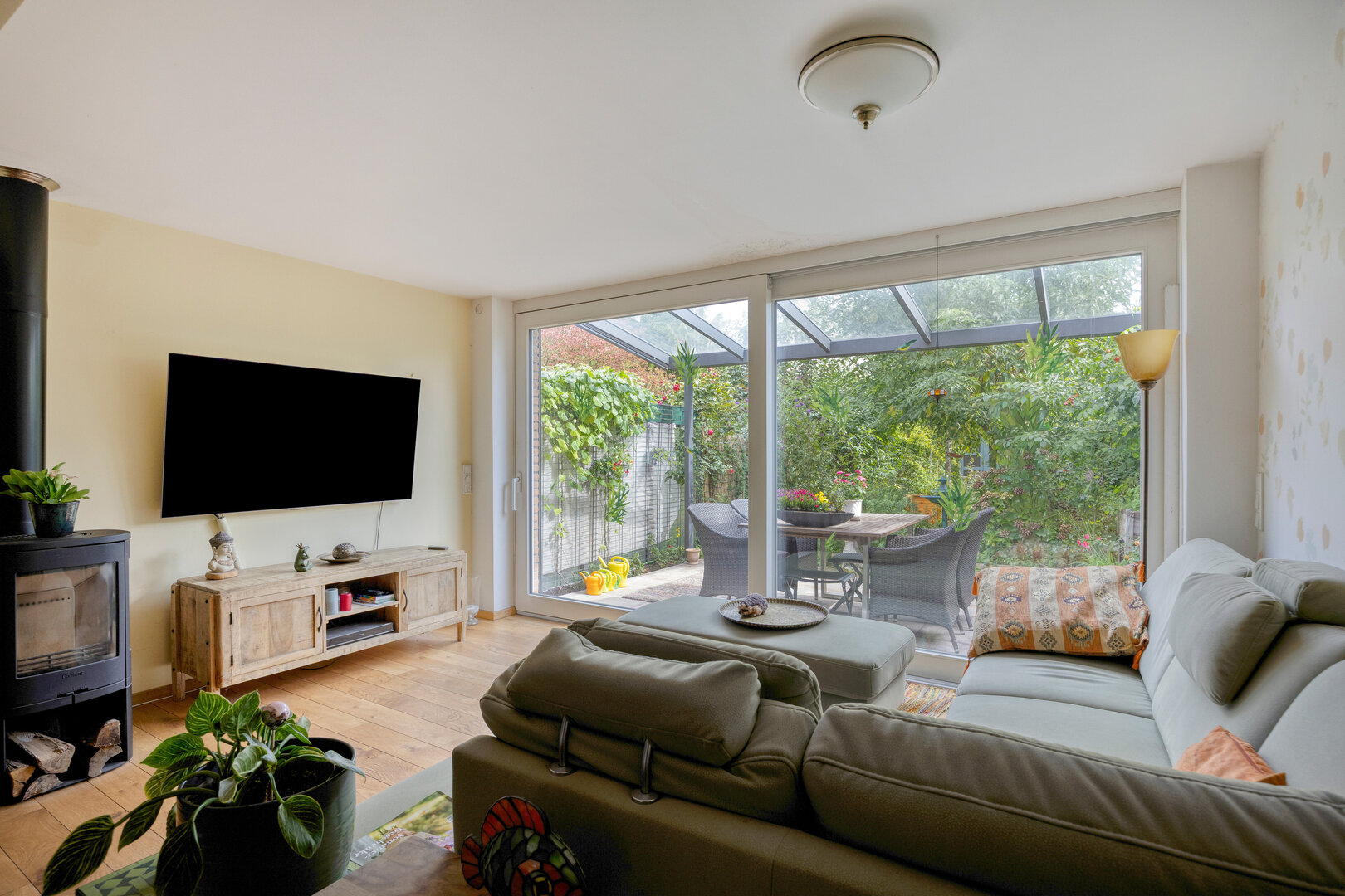 Reihenmittelhaus Münster-Aaseestadt – Wohnbereich mit Kaminofen und hausbreiten Glasschiebetüren zum Garten