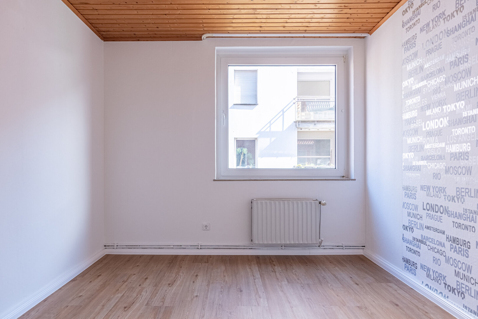 Wohnung 04 – Zimmer mit Holzdecke und großem Fenster